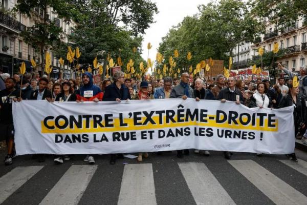 Orang-orang memegang spanduk saat demonstrasi menentang partai sayap kanan National Rally di Paris, Prancis , 15 Juni 2024. REUTERS 