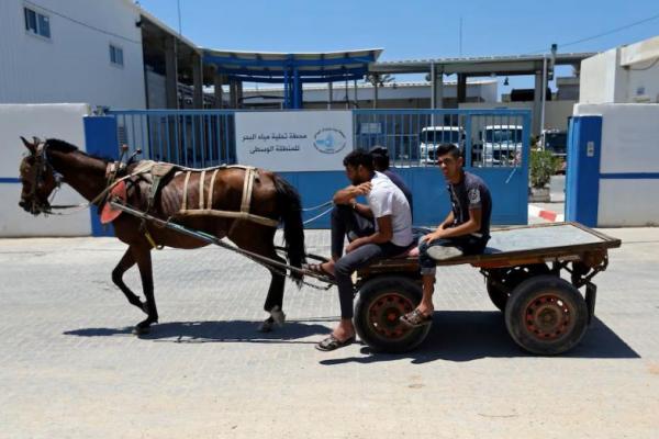 Warga Palestina mengendarai kereta kuda melewati pabrik desalinasi Gaza, di Jalur Gaza tengah 23 Juni 2019. REUTERS 