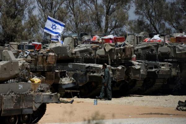 Seorang tentara Israel berjalan di dekat kendaraan militer, dekat perbatasan Israel dengan Gaza di Israel selatan, 29 Mei 2024. REUTERS 