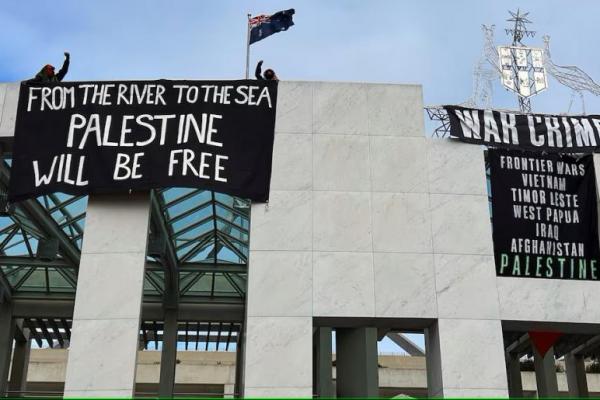 Pengunjuk rasa pro-Palestina menggantung spanduk di atap gedung Gedung Parlemen Australia di Canberra, Australia, 4 Juli 2024. REUTERS 