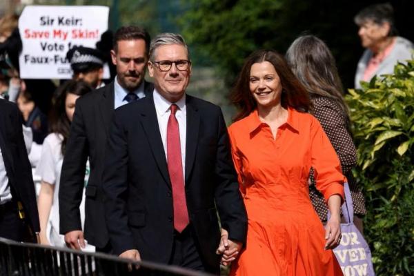 Pemimpin Partai Buruh oposisi Inggris Keir Starmer dan istrinya Victoria Starmer berjalan di luar tempat pemungutan suara di London, Inggris, 4 Juli 2024. REUTERS 