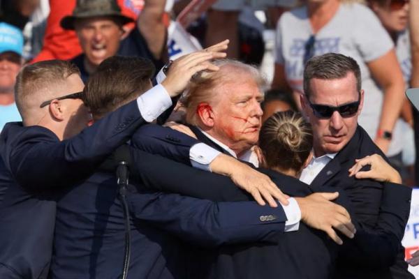 Kandidat presiden AS Donald Trump memberi isyarat dengan wajah berlumuran darah saat kampanye di Butler Farm Show di Butler, Pennsylvania, AS, 13 Juli 2024. REUTERS 