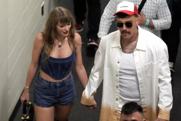 Taylor Swift dan Travis Kelce berpegangan tangan di Stadion Arrowhead. (FOTO: AP) 