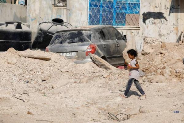 Seorang anak Palestina berjalan di sepanjang jalan yang rusak, di kamp Jenin, di Tepi Barat yang diduduki Israel, 6 September 2024. REUTERS 