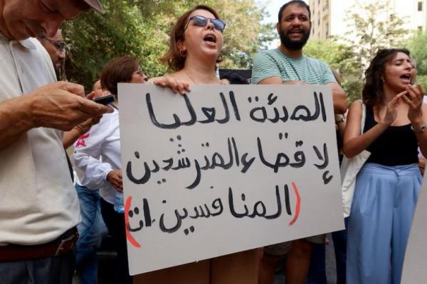 Seorang demonstran membawa spanduk selama protes menuntut pengembalian tiga kandidat dalam Pilpres, di dekat markas Komisi Pemilihan Umum di Tunis, Tunisia, 2 September 2024. REUTERS 