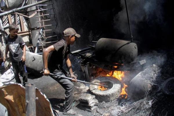 Seorang warga Palestina membakar sampah plastik untuk menghasilkan bahan bakar alternatif di tengah kelangkaan di Jalur Gaza utara, 5 September 2024. REUTERS 