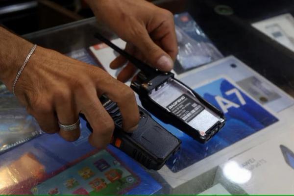 Seorang penjual menunjukkan perangkat walkie-talkie tanpa baterai, yang katanya ia singkirkan demi alasan keamanan, di pinggiran selatan Beirut, Lebanon, 18 September 2024. REUTERS 