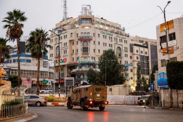 Sebuah kendaraan militer bergerak di jalan di luar gedung tempat kantor Al Jazeera berada, di Ramallah, di Tepi Barat yang diduduki Israel, 22 September 2024. REUTERS 