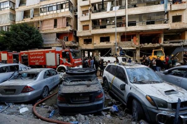 Orang-orang berkumpul di dekat truk pemadam kebakaran di lokasi serangan Israel di pinggiran selatan Beirut, Lebanon 21 September 2024. REUTERS 