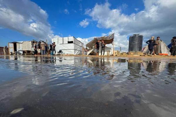 Warga Palestina yang mengungsi berkumpul saat berlindung di kamp tenda yang banjir setelah hujan, di Khan Younis, di Jalur Gaza selatan, 22 September 2024. REUTERS 