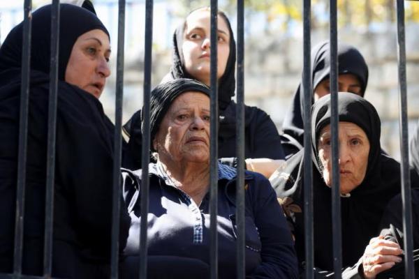 Para wanita berduka atas tiga anggota keluarga yang tewas dalam serangan Israel saat pemakaman mereka di Joun, Lebanon, 26 September 2024. REUTERS 