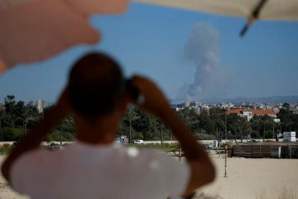 Seorang pria menyaksikan asap mengepul di Lebanon selatan menyusul serangan Israel, seperti  terlihat dari Tyre, Lebanon, 26 September 2024. REUTERS 