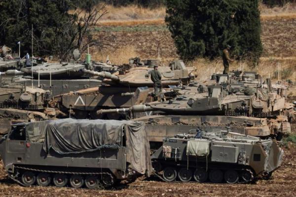 Orang-orang bekerja di tank Angkatan Darat Israel, di Israel utara, 27 September 2024. REUTERS 