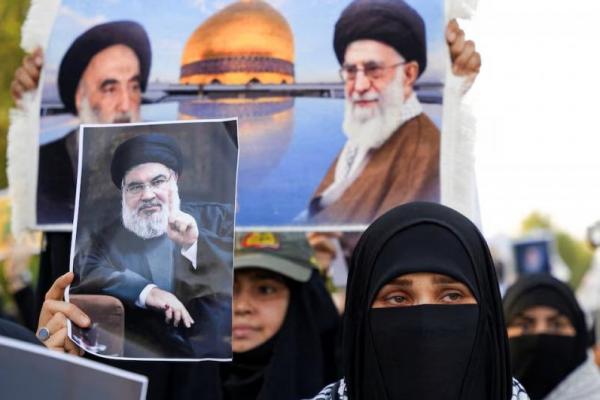 Seorang wanita memegang foto Pemimpin Hizbullah Lebanon Hassan Nasrallah selama pemakaman simbolis di Basra, Irak, 29 September 2024. REUTERS 