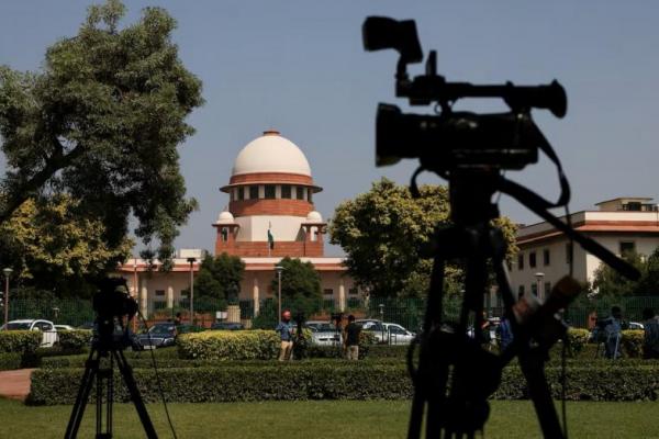 Reporter berbicara di depan kamera di luar gedung Mahkamah Agung di New Delhi, India, 13 Oktober 2022. REUTERS 