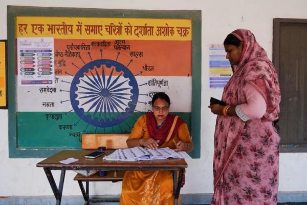 Seorang petugas di bilik suara membantu seorang pemilih di luar tempat pemungutan suara di Karnal, di negara bagian utara Haryana, India, 5 Oktober 2024. REUTERS 