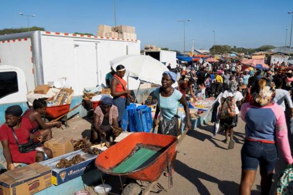 Seorang wanita mendorong gerobak dorong setelah warga Haiti diizinkan masuk ke pasar di kota perbatasan Dajabon, Republik Dominika, 18 Maret 2024. REUTERS  