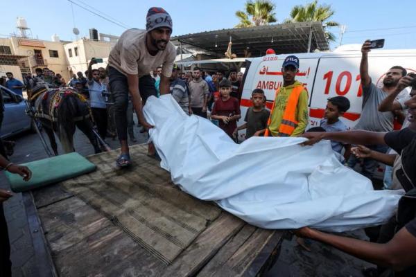 Seorang warga Palestina membawa jenazah di Rumah Sakit Syuhada Al-Aqsa, di Deir Al-Balah, Jalur Gaza tengah, 10 Oktober 2024. REUTERS 