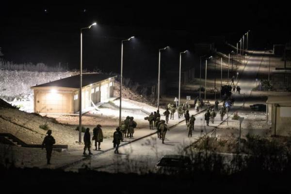 Tentara Israel berjalan di dekat lokasi di mana pesawat nirawak dari Lebanon menyerang Israel, di Binyamina Israel, 13 Oktober 2024. REUTERS 