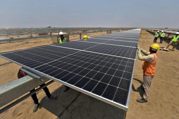 Pekerja memasang panel surya di Khavda Renewable Energy Park milik Adani Green Energy Ltd di Khavda, India, 12 April 2024. REUTERS 