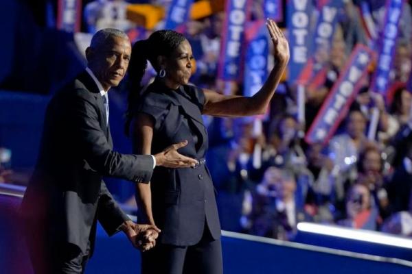 Mantan ibu negara AS Michelle Obama dan suaminya, mantan Presiden AS Barack Obama, di panggung Konvensi Nasional Demokrat di Chicago, Illinois, AS, 20 Agustus 2024. REUTERS 