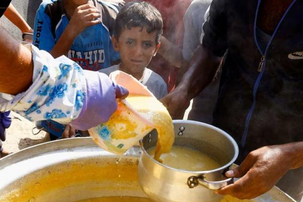 Seorang anak Palestina ikut berkumpul untuk menerima makanan yang dimasak oleh dapur amal, di Khan Younis di Jalur Gaza selatan. REUTERS 