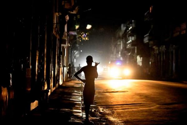 Orang-orang berdiri di jalan pada malam hari saat Kuba dilanda pemadaman listrik di seluruh pulau, di Havana, Kuba, 18 Oktober 2024. REUTERS 