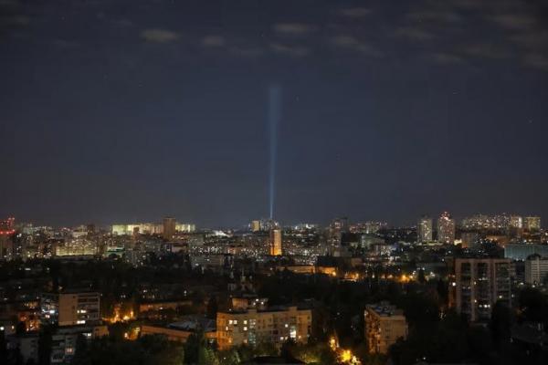 Personel layanan Ukraina menggunakan lampu sorot untu mencari pesawat nirawak di langit atas pusat kota, di Kyiv, Ukraina, 20 Oktober 2024. REUTERS 