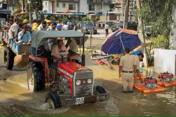 Pekerja mengendarai traktor melalui jalan yang banjir setelah hujan lebat di Bengaluru, India, 22 Oktober 2024. REUTERS 