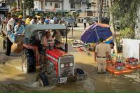 Pekerja mengendarai traktor melalui jalan yang banjir setelah hujan lebat di Bengaluru, India, 22 Oktober 2024. REUTERS