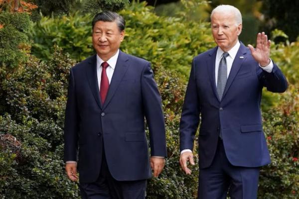 AS Presiden Joe Biden melambaikan tangan saat berjalan bersama Presiden Tiongkok Xi Jinping di Woodside, California, AS, 15 November 2023. REUTERS 