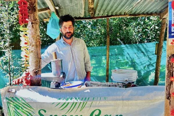 Maqsood Ahmad Ganai, seorang doktor di bidang botani, di kedai jusnya di Hugam, Anantnag, Kashmir yang dikelola India. (FOTO: AL JAZEERA) 