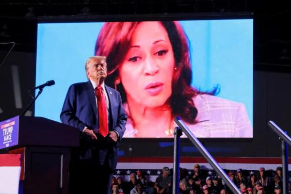 Ekspresi Capres Partai Republik Donald Trump saat wajah capres Partai Demokrat Kamala Harris muncul di layar, di Huntington Place di Detroit, Michigan, AS, 18 Oktober 2024. REUTERS 