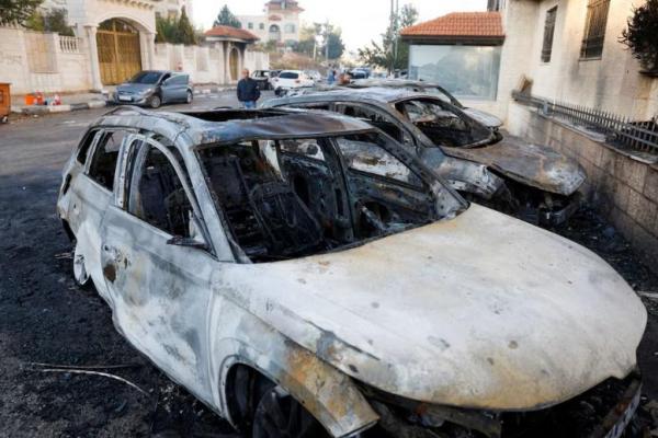 Warga Palestina melihat mobil yang rusak setelah serangan pemukim Israel di kota Al-Bireh, di Tepi Barat yang diduduki Israel, 4 November 2024. REUTERS 