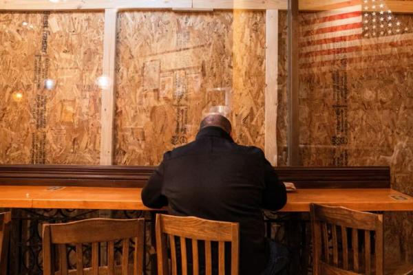 Seseorang makan di dalam restoran dengan kayu lapis yang menutupi jendela di dekat Gedung Putih di Washington, AS, 4 November 2024. REUTERS 