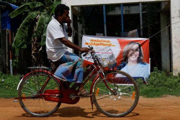 Seorang pria bersepeda melewati poster calon presiden dari Partai Demokrat AS Kamala Harris di Thulasendrapuram, Tamil Nadu, India 4 November 2024. REUTERS 