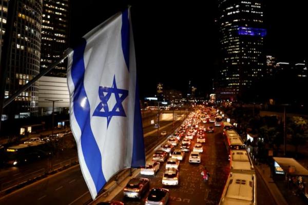 Bendera nasional Israel berkibar di atas jalan raya kota selama jam sibuk, di Tel Aviv, Israel, 4 November 2024. REUTERS 