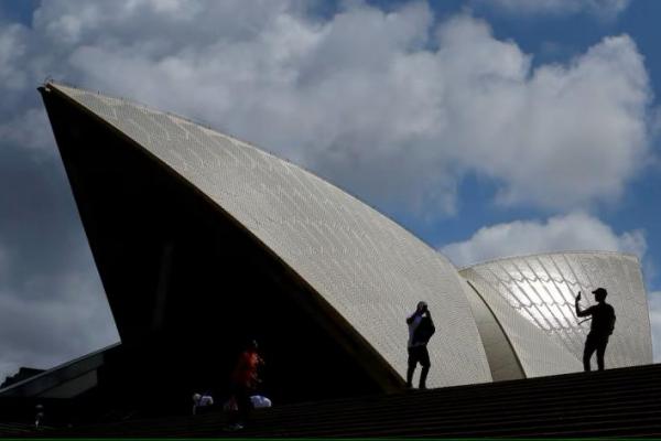 Turis mengambil foto dengan ponsel mereka di depan Gedung Opera Sydney di Sydney, Australia, 14 Oktober 2018. REUTERS 