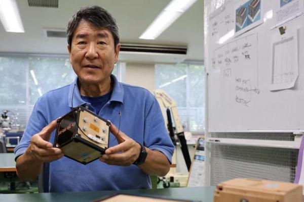 Takao Doi, mantan astronot Jepang dan profesor di Universitas Kyoto, memegang model rekayasa LignoSat di Universitas Kyoto di Kyoto, Jepang, 25 Oktober 2024. REUTERS 