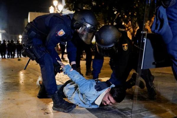 Petugas polisi berjaga saat warga memprotes penanganan tanggap darurat banjir bandang di Spanyol timur, di Valencia, Spanyol, 9 November 2024. REUTERS 