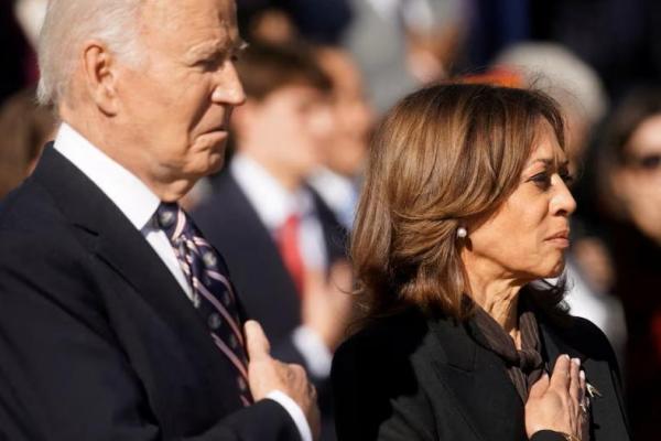 Presiden AS Joe Biden dan Wakil Presiden Kamala Harris mendengarkan lagu kebangsaan selama upacara Hari Veteran di Arlington, Virginia, AS, 11 November 2024. REUTERS 