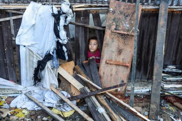 Seorang anak melihat saat warga Palestina memeriksa lokasi serangan Israel terhadap tenda-tenda pengungsi, di Deir Al-Balah di Jalur Gaza tengah 13 November 2024. REUTERS 