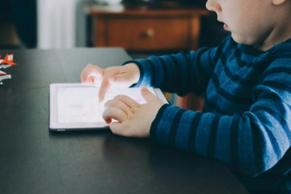 Ilustrasi, seorang anak sedang bermain gadget (Foto: Unsplash/Kelly Sikkema)  