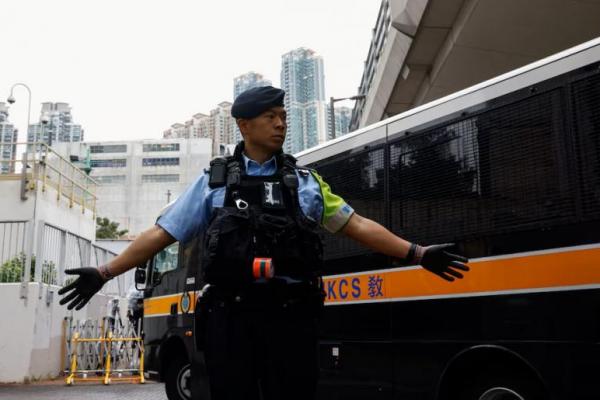 Seorang petugas polisi berjaga saat mobil tahanan tiba di gedung Pengadilan Magistrat Kowloon Barat, di Hong Kong, Tiongkok, 19 November 2024. REUTERS 