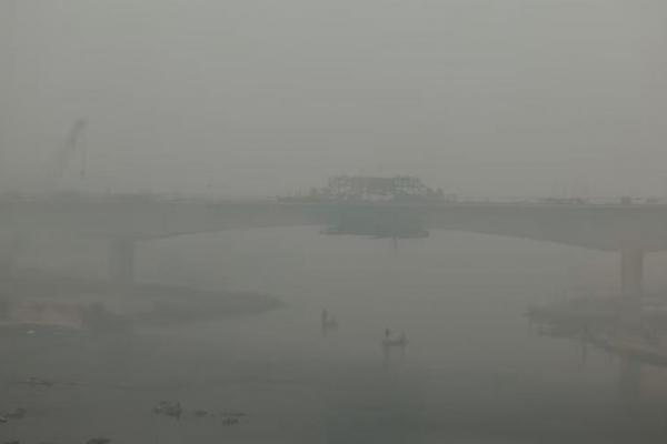 Orang-orang naik perahu di sungai Yamuna, saat langit diselimuti kabut asap di New Delhi, India, 18 November 2024. REUTERS 