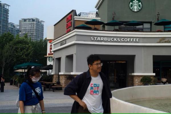 Orang-orang berjalan melewati kedai kopi Starbucks di Beijing, China, 22 Mei 2024. REUTERS 