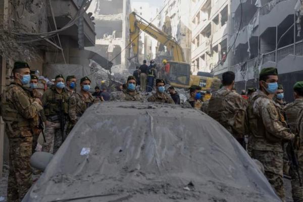 Anggota pertahanan sipil bekerja saat tentara Lebanon berjaga di lokasi serangan Israel di lingkungan Basta, Beirut, 23 November 2024. REUTERS 