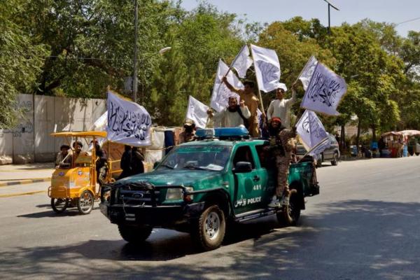 Anggota Taliban membawa bendera saat unjuk rasa menandai peringatan tiga tahun jatuhnya Kabul, di Afghanistan, 14 Agustus 2024. REUTERS 