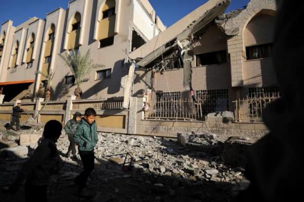 Anak-anak Palestina berjalan di lokasi serangan Israel di sekolah yang menampung orang-orang terlantar, di Kota Gaza 27 November 2024. REUTERS 