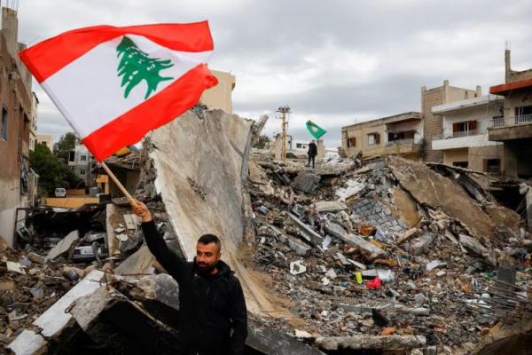 Seorang pria melambaikan bendera Lebanon setelah gencatan senjata antara Israel dan kelompok Hizbullah, di Tyre, Lebanon, 27 November 2024. REUTERS 